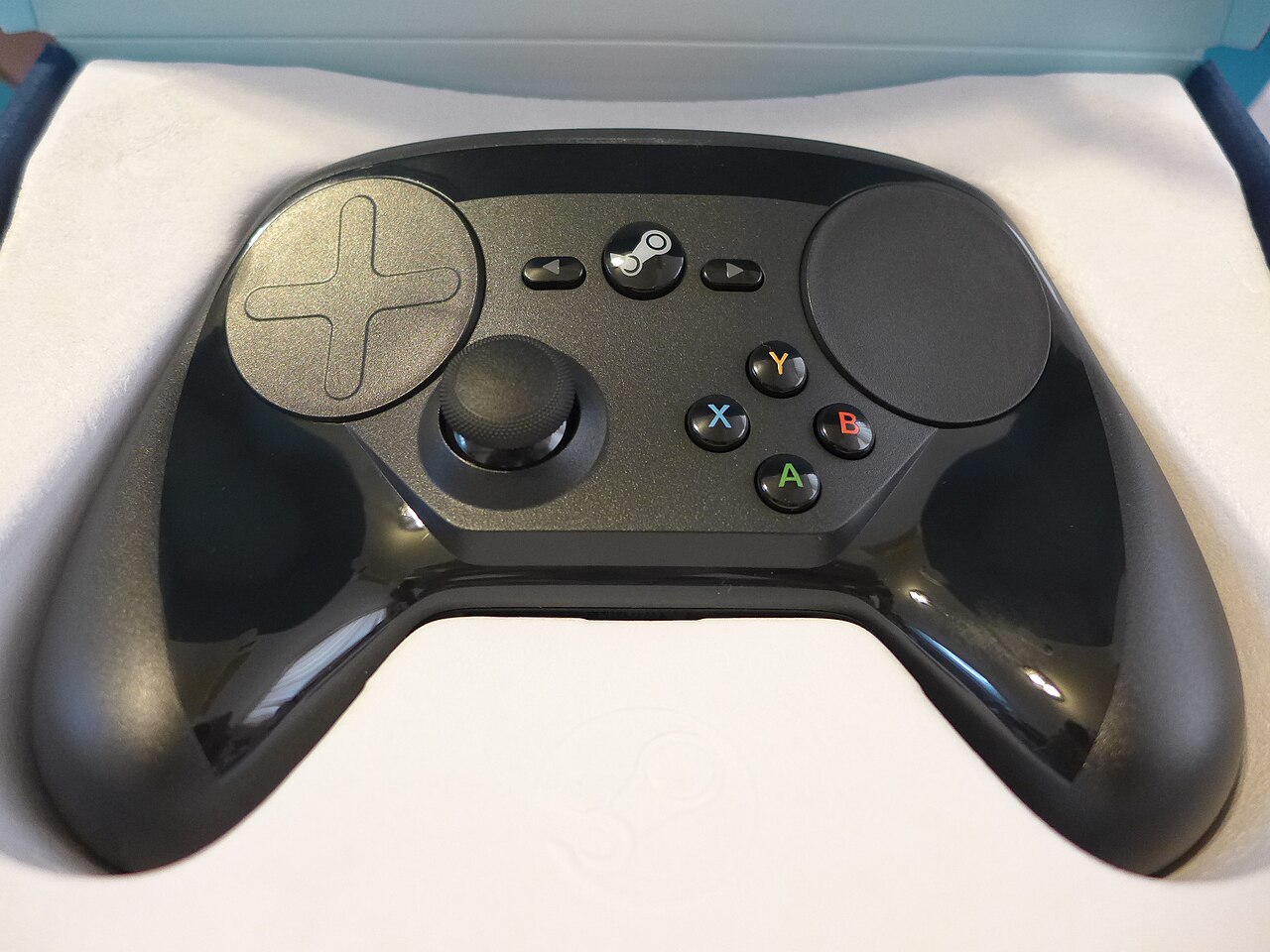 두 원형 트랙패드와 왼쪽 아날로그 스틱, 오른쪽 A·B·X·Y 버튼이 보이는 검은색 Steam Controller(2015)